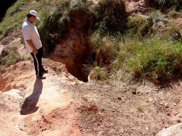 Matthew climbing out of a hole