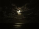 The moon was glowing through the clouds.