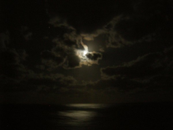 The moon was glowing through the clouds.