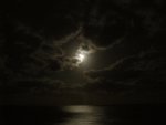 The moon was glowing through the clouds.