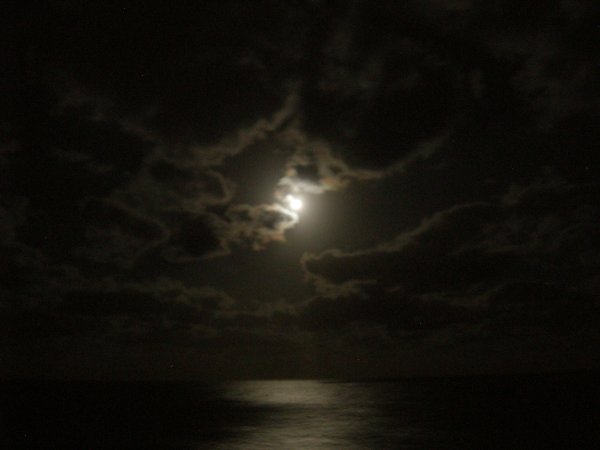 The moon was glowing through the clouds.