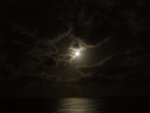 The moon was glowing through the clouds.
