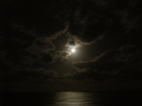 The moon was glowing through the clouds.